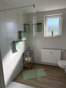 a bathroom with a sink and a toilet and a window at Ferienwohnung RaHo in Wadgassen +21 photos