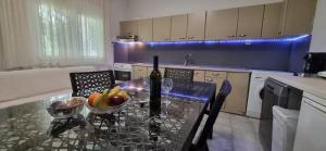 a kitchen with a table with a bottle of wine and fruit at Galini Cosy Home in Asprovalta