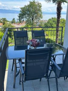 a table and chairs on a balcony with the ocean at Apartmani ViVa in Lovran