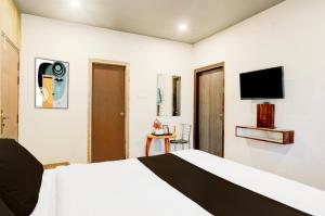 a hotel room with a bed and a flat screen tv at Hotel Pratishtha in Guwahati