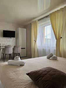 a white bedroom with a large bed with a window at Hotel DALIM in Duliby