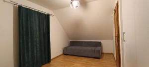 a room with a chair and a green curtain at Domek w Sielpi in Sielpia Wielka