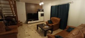 a living room with a couch and chairs and a tv at Domek w Sielpi in Sielpia Wielka