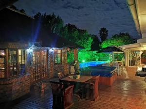 a patio with a swimming pool at night at Junior Suite with Pool View - in Port Elizabeth