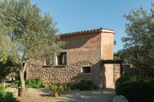 a stone building with a tree in front of it at Finca Son Vidal in Llucmajor