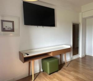 a room with a desk with a television on the wall at Hotel Brasa in Elvas