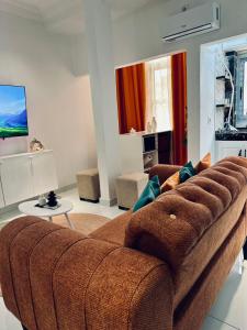 a large brown couch in a living room at Dyden luxury appartement in Douala