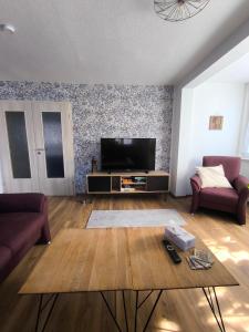 a living room with a television and a table at Ferienwohnung Schelklewiese in Baiersbronn