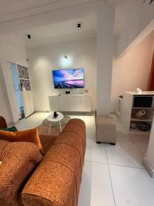 a living room with a couch and a flat screen tv at Dyden luxury appartement in Douala +25 photos