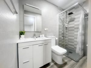 a bathroom with a toilet and a sink and a shower at Apartamento con patio cerca de la playa in Bueu