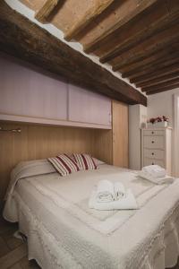 a bedroom with a large bed with towels on it at Bargello House by FrancigenaApartments in Siena