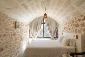 a bedroom with a white bed with a large window at Finca Son Vidal in Llucmajor