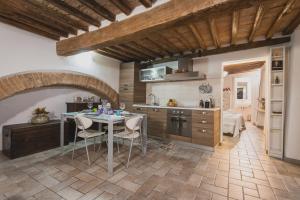 a kitchen with a table and chairs in a room at Bargello House by FrancigenaApartments in Siena