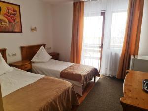 a hotel room with two beds and a window at Casa Magica Busteni in Buşteni