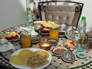 a table with a plate of breakfast foods and drinks at Riad AYA in Rabat