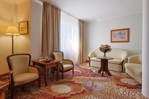 a living room with chairs and a couch and a table at Hotel Lubicz in Ustka
