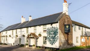 a white building with a mural on the side of it at The Countryman Inn in Wool