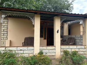 a house with a porch with chairs on it at Bella - Rosa in Ficksburg