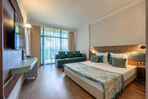a hotel room with a bed and a couch at Kristal Hotel - All inclusive - Fully renovated in Golden Sands