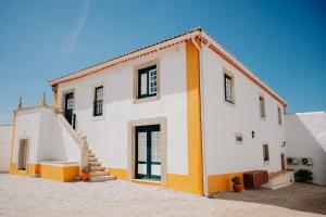 a white house with a yellow and white at Casa de Campo da Quinta da Pegada in Óbidos