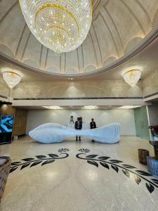 two people standing in a lobby with a large chandelier at Vetiver Grand in Jabalpur