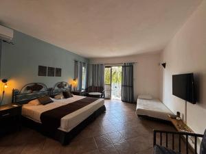 a hotel room with two beds and a television at Tam Studio in La Gaulette