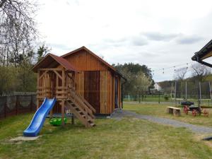 a playground with a slide and a play structure at Zielone Rykowisko - Myśliwski domek całoroczny in Blizów