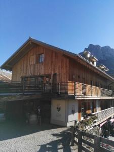 a large wooden building with a balcony on it at Ciasa Savoy in Vigo di Fassa