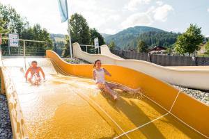 two children playing on a water slide at a water park at Mariengut - Natur Aparthotel Kramer in Wagrain +105 photos