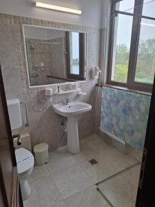 ein Badezimmer mit Waschbecken, Toilette und Dusche in der Unterkunft Hotel Insula in Neptun + 112 Fotos