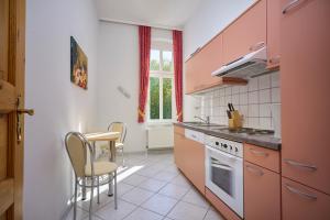 a kitchen with pink cabinets and a table and chairs at Appartement 06 Strandvillen Wald & See in Zinnowitz