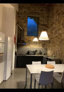 a kitchen with a table and chairs and a refrigerator at Casa Branca AL in Monchique