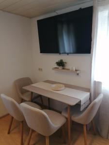 a table and chairs with a television on the wall at Thomas Haus 1 in Günzburg