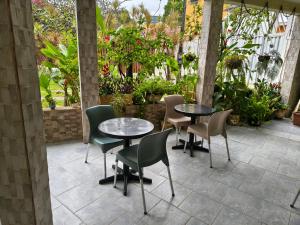 a patio with two tables and chairs and plants at Hotel Veleiro de Porto in Porto De Galinhas