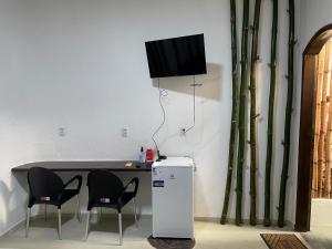 a table with chairs and a television on a wall at Casa Sankofa de Belém in Belém
