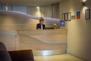 a woman sitting at a counter in a store at Sure Hotel by Best Western Aberdeen in Aberdeen