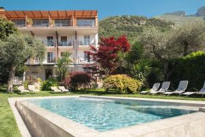 a swimming pool in front of a building at Eco Hotel Ariston in Malcesine