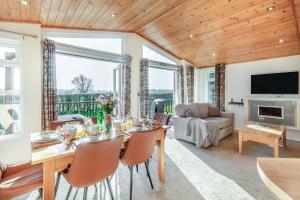 a dining room with a table and chairs and a couch at Field View 2 bed-No pets-Hornbeam in Eye +11 photos
