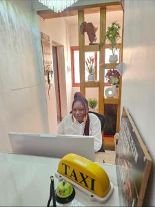 a woman sitting at a table with a laptop at Hotel liberté 6 in Dakar
