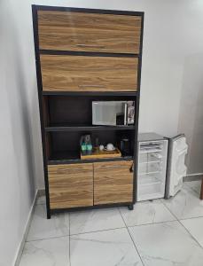 a wooden dresser with a microwave in a room at Hotel liberté 6 in Dakar