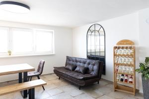a living room with a leather couch and a table at Apartmán Marie in Mutěnice +12 photos