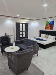 a living room with a bed and a couch and chairs at Hotel liberté 6 in Dakar +46 photos
