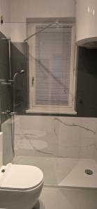 a bathroom with a toilet and a shower with a window at La Casetta al Lago in Sorico +28 photos