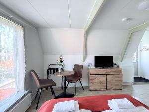 a bedroom with a bed and a table and chairs at Hotel - Cafe De Harmonie in Edam