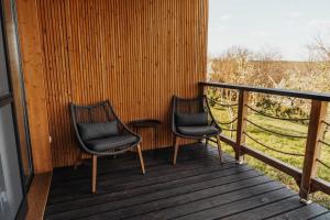 two chairs and a table on a porch at Faház - Panoráma in Véménd