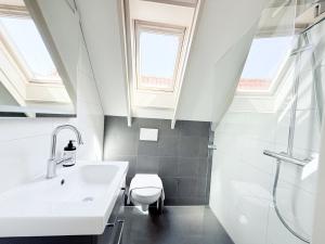 a white bathroom with a sink and a toilet at Hotel - Cafe De Harmonie in Edam +23 photos