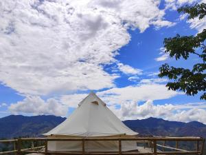 a white tent under a cloudy sky with mountains at Infinite horizon nan in Ban San Khet Yao