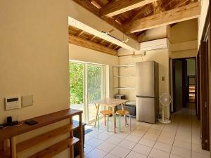 a kitchen with a table and a refrigerator at Green Rabbit House by private beach in Ishigaki Island