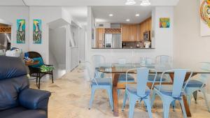 a dining room with a glass table and blue chairs at 405 Mariners Club in Key Largo