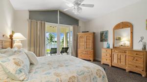 a bedroom with a bed and a dresser and a mirror at 405 Mariners Club in Key Largo +42 photos